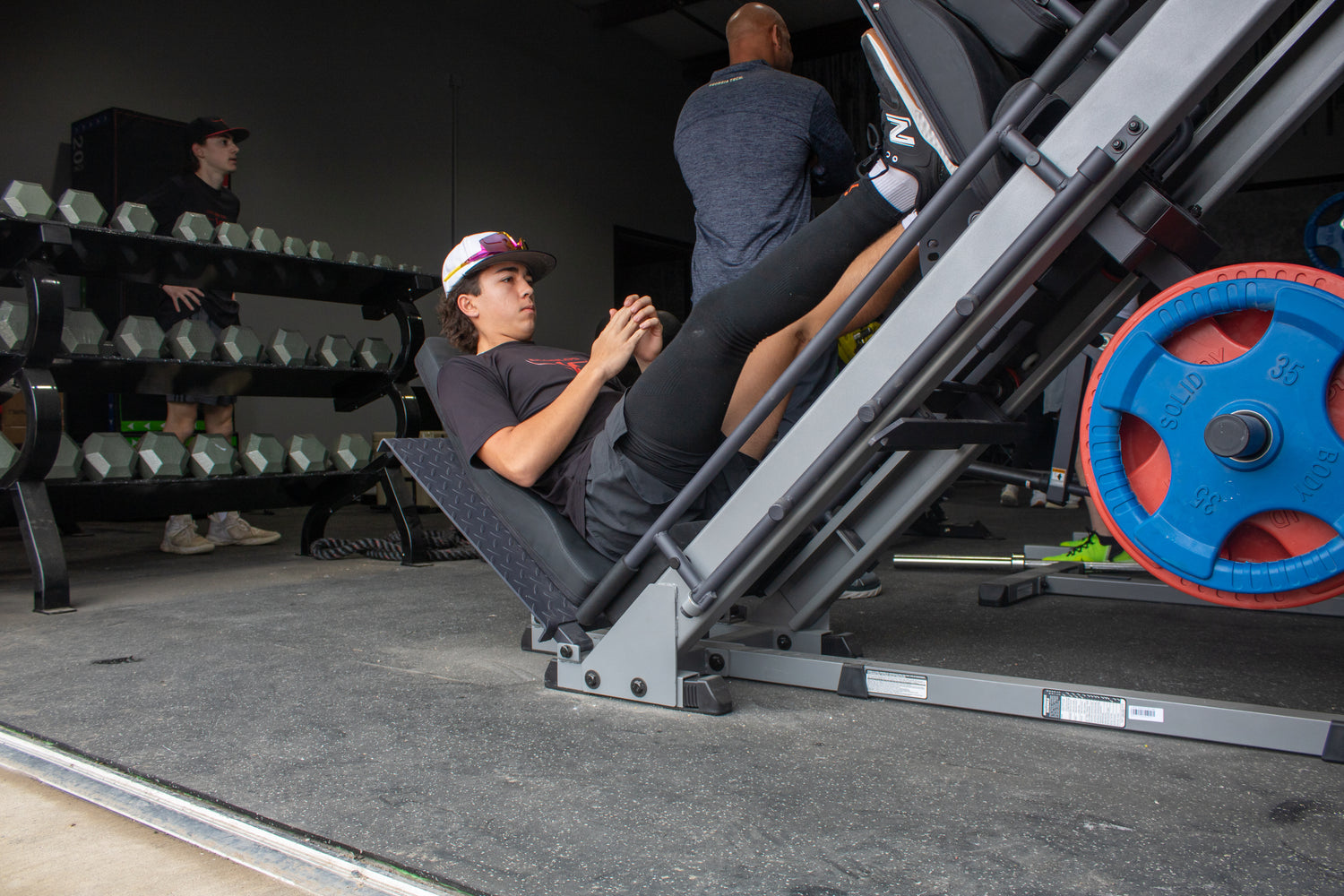Person using a leg press machine in a gym setting