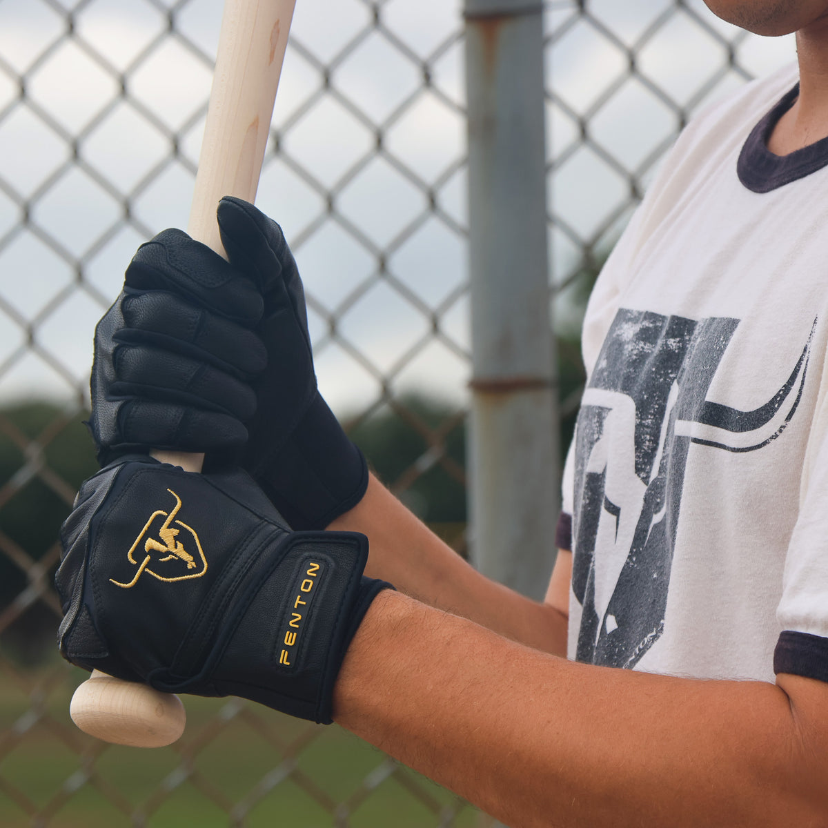 Baseball player holding a bat wearing Cobra batting gloves