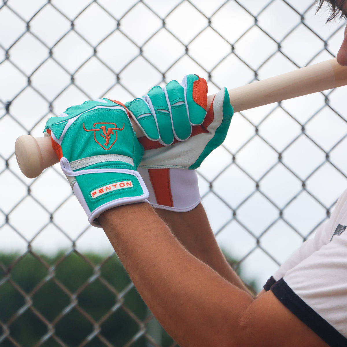 Baseball player holding a bat wearing Fins batting gloves